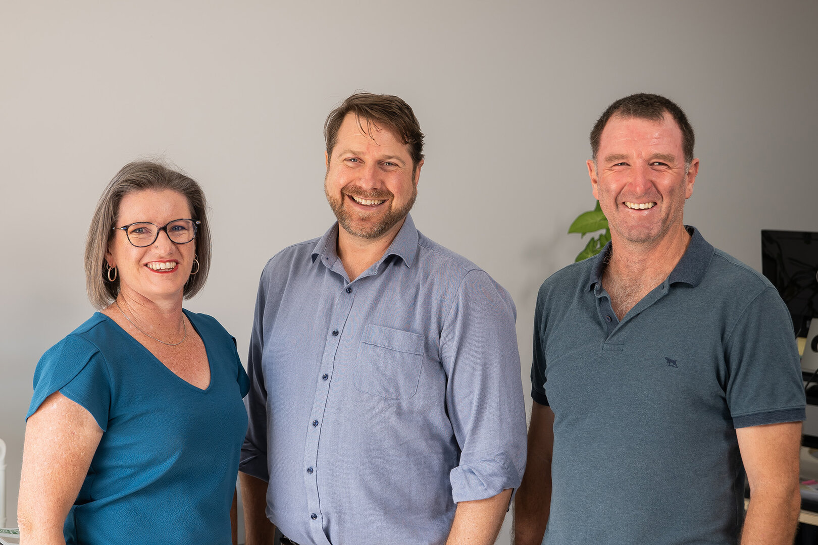 Majella, Paul, and Keith stand together for a photo in their office.